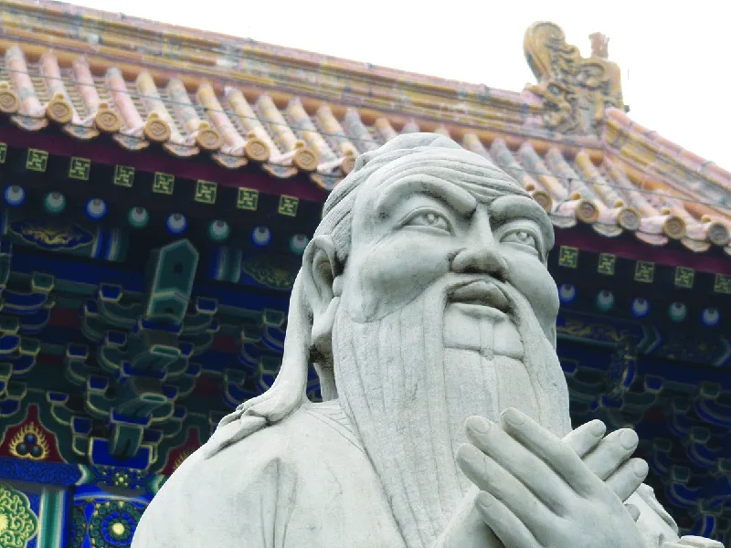 Figure 2.4 Confucius (Kung Fu-tzu or Master Kung), depicted here in front of the Confucius Temple in Beijing, lived during a turbulent period in China’s history. He sought to end violence and chaos through a return to order, harmony, and reverence, especially within the family. (credit: “KongZi, Confucius Temple with Gold Roof, Main Statue” by “klarititemplateshop.com”/Flickr, CC BY 2.0)