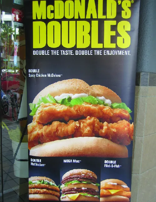 Figure 9.3 When an unwise purchase is made appealing, where does the consumer’s responsibility for decision-making lie? Furthermore, if the purchase is spurred by children who are responding to advertising specifically directed at them, is consumer responsibility diminished? (credit: “Big Burgers - Asia (5490379696)” by Kinoko kokonotsu/Wikimedia Commons, CC BY 2.0)